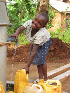 Ugandan girl at a well (wikipedia)